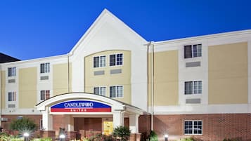 Um hotel com uma placa grande de 'CANDLEWOOD SUITES', várias janelas e fachada de tijolos.