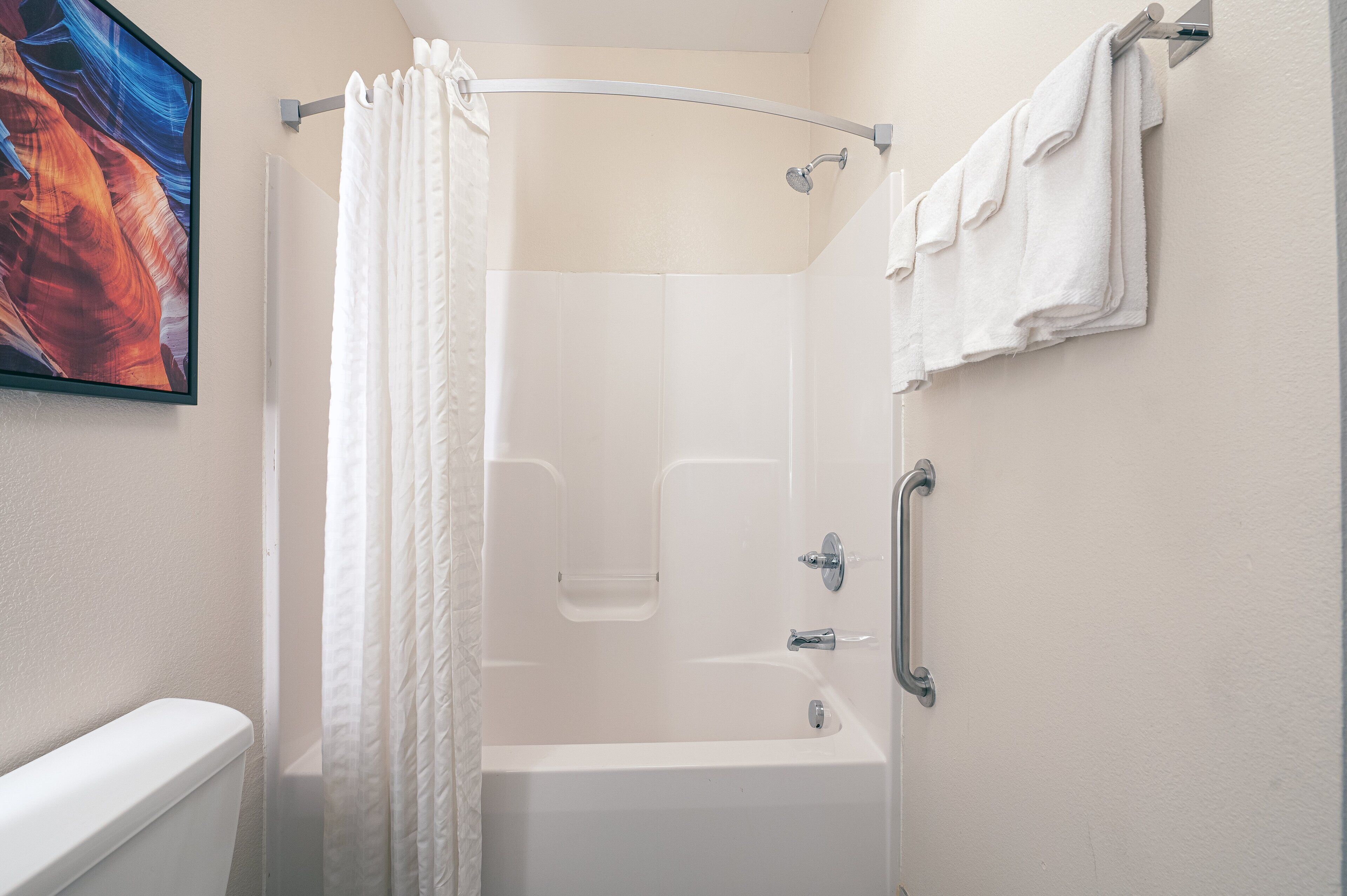 Un baño con bañera, cortina de ducha y un perchero.