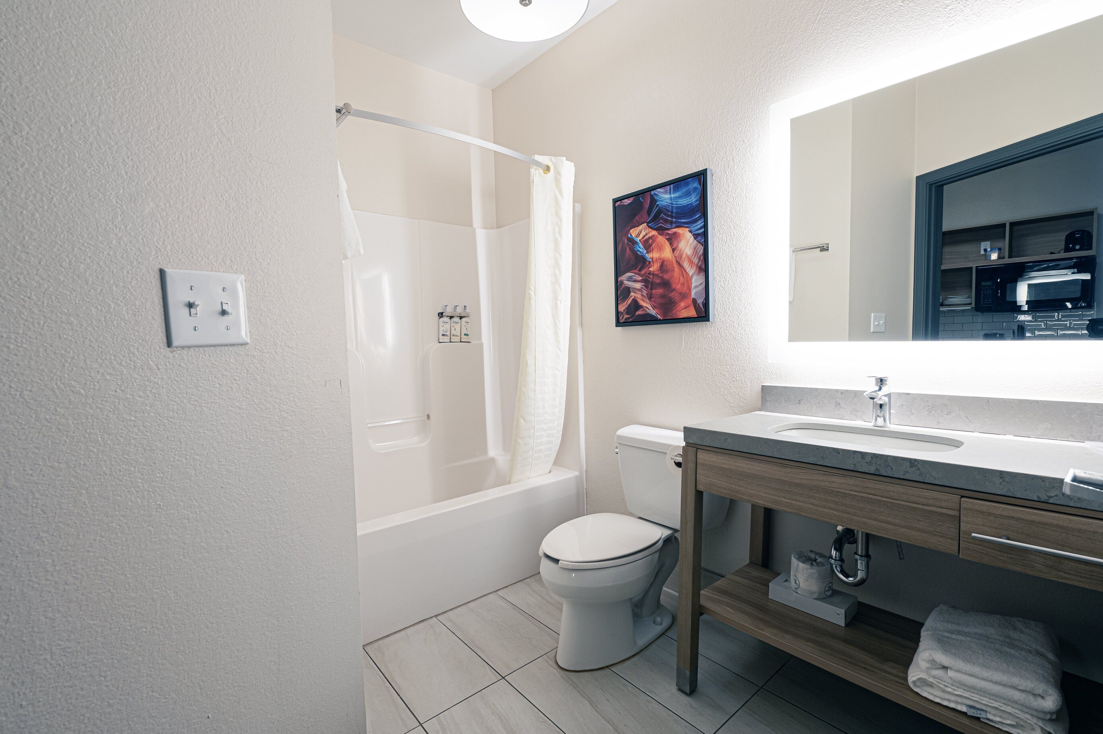 A modern bathroom with a bathtub, toilet, and sink.