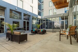 A modern outdoor seating area with wicker furniture and potted plants.