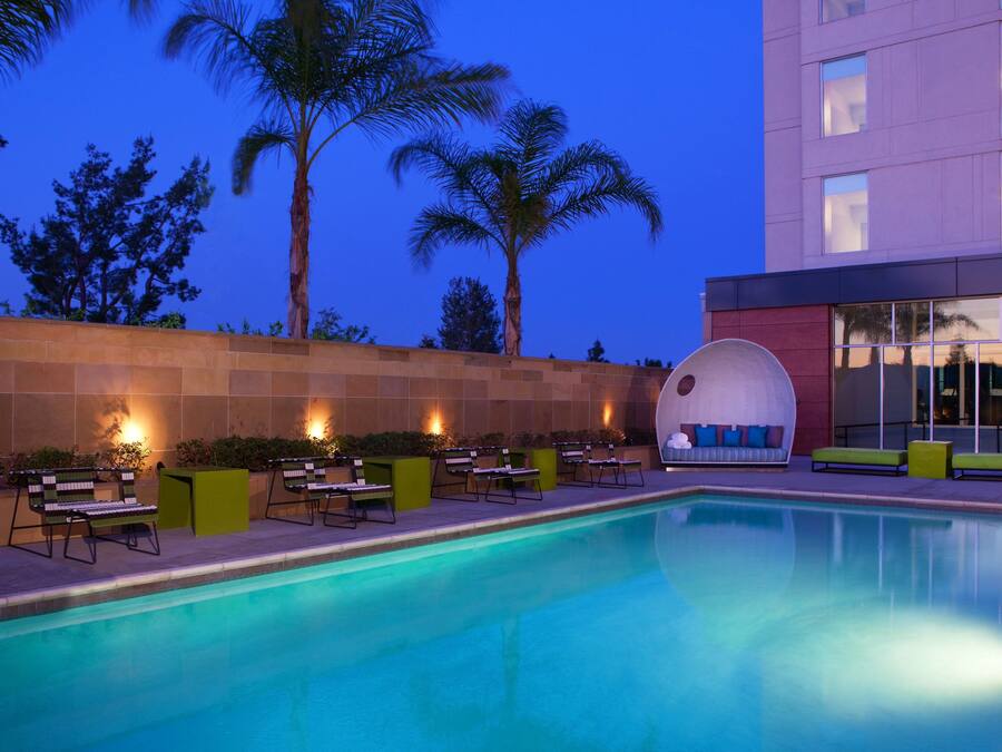 Una piscina al aire libre, sillones reclinables de piscina