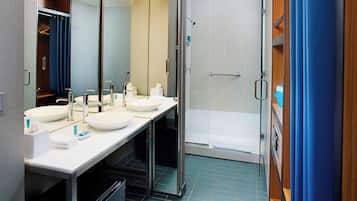 Une salle de bain moderne avec deux lavabos, un miroir et un espace douche.