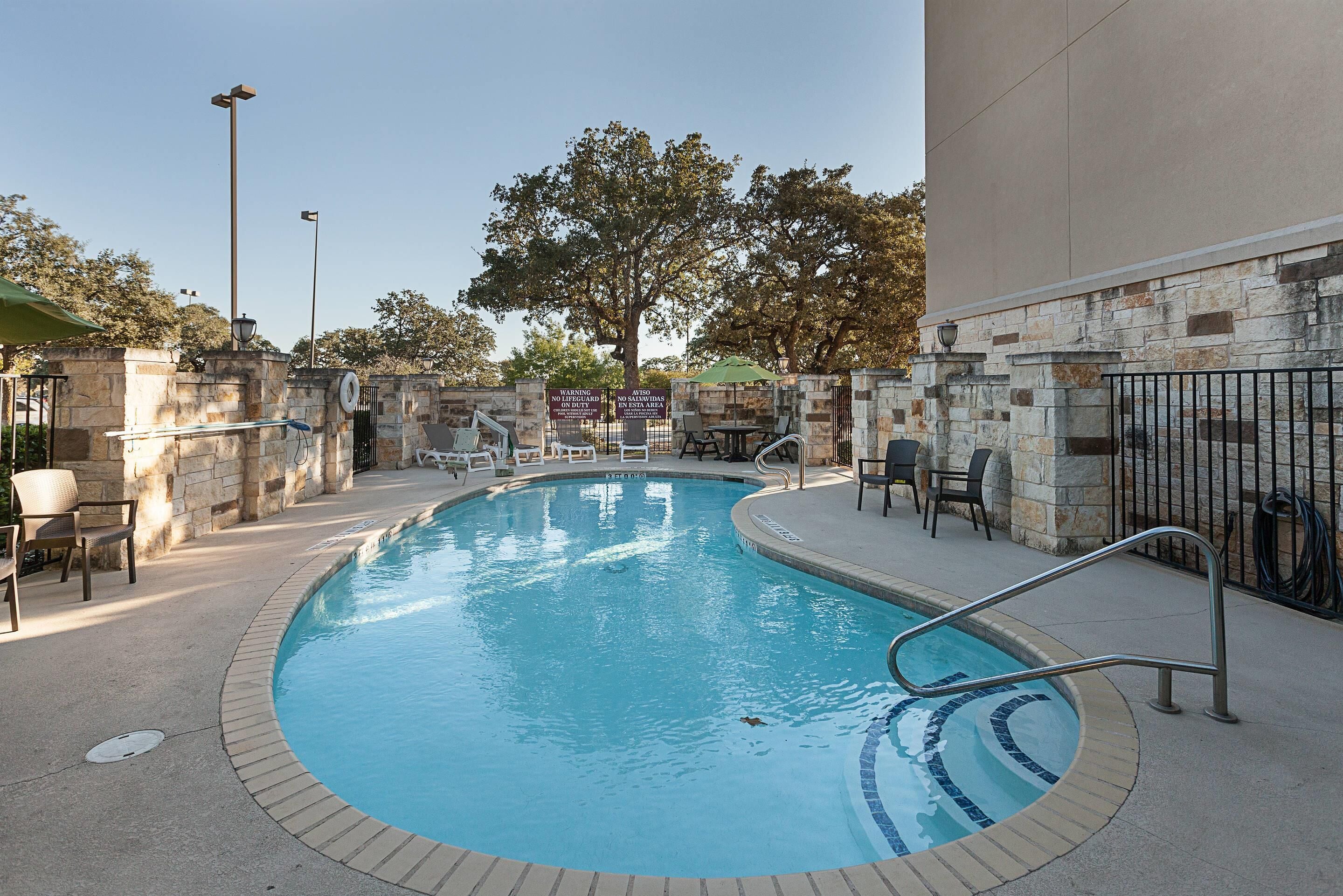 Una piscina al aire libre de temporada, sombrillas