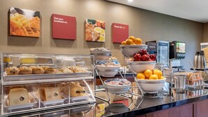 A breakfast buffet with various food items, including waffles, eggs, and fruits, and a coffee machine. - Comfort Suites San Antonio North - Stone Oak (San Antonio)