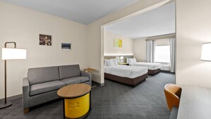 A hotel room with a sofa, a round table, a bed, and a chair. - Comfort Suites San Antonio North - Stone Oak (San Antonio)