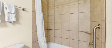 A bathroom with a bathtub, shower, and toilet.