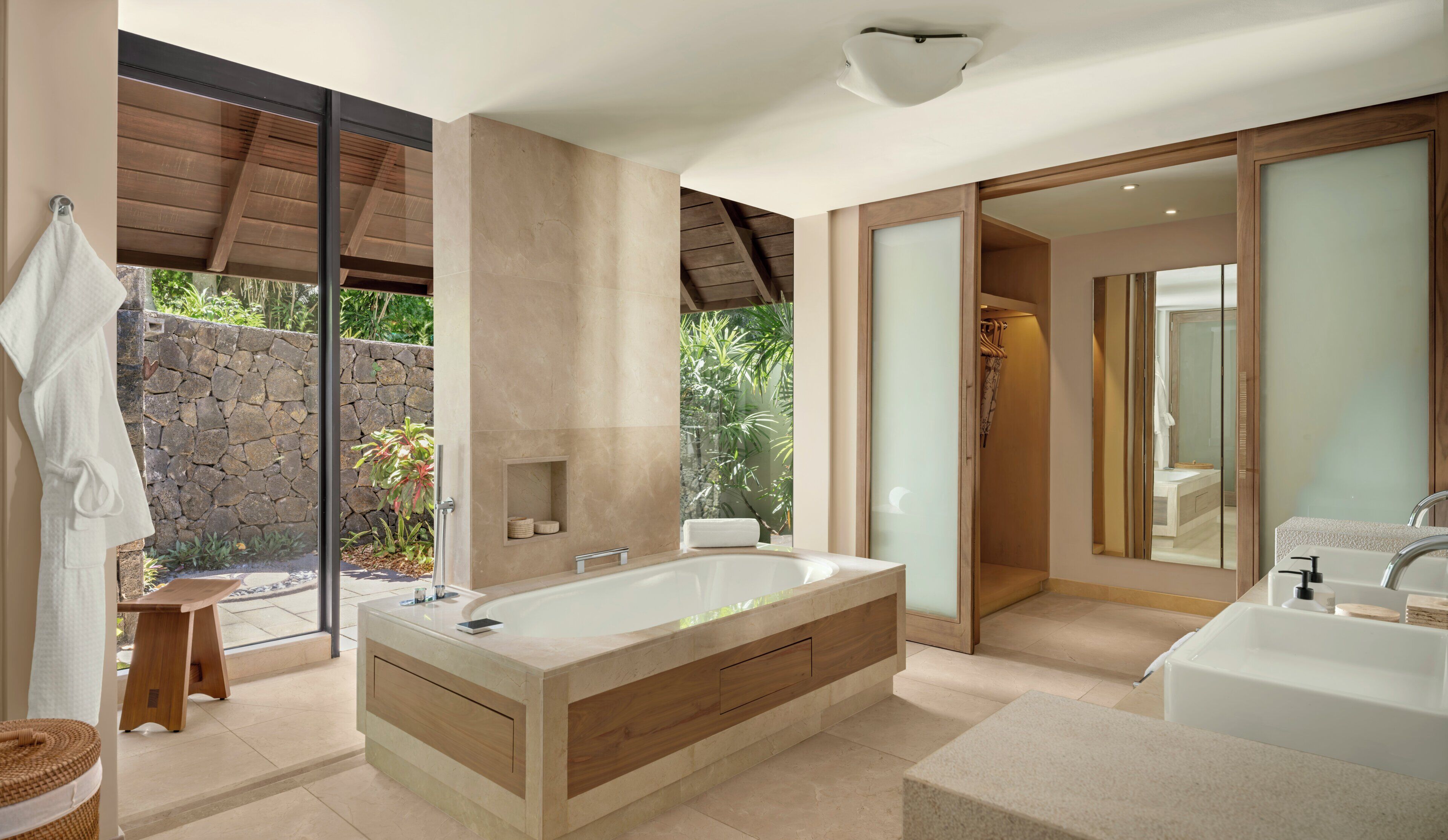 A modern bathroom with a large bathtub, a separate shower area, and a vanity with a mirror.