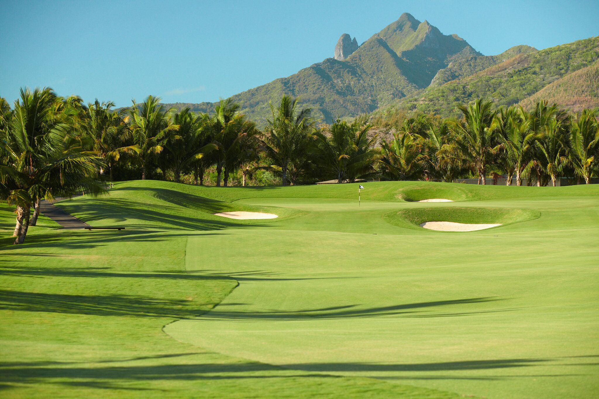 A golf course with a clear view of a mountain in the background.