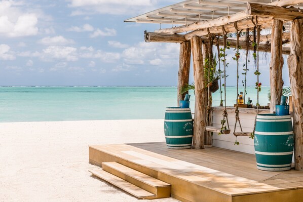A wooden structure with a roof overlooking a beach.