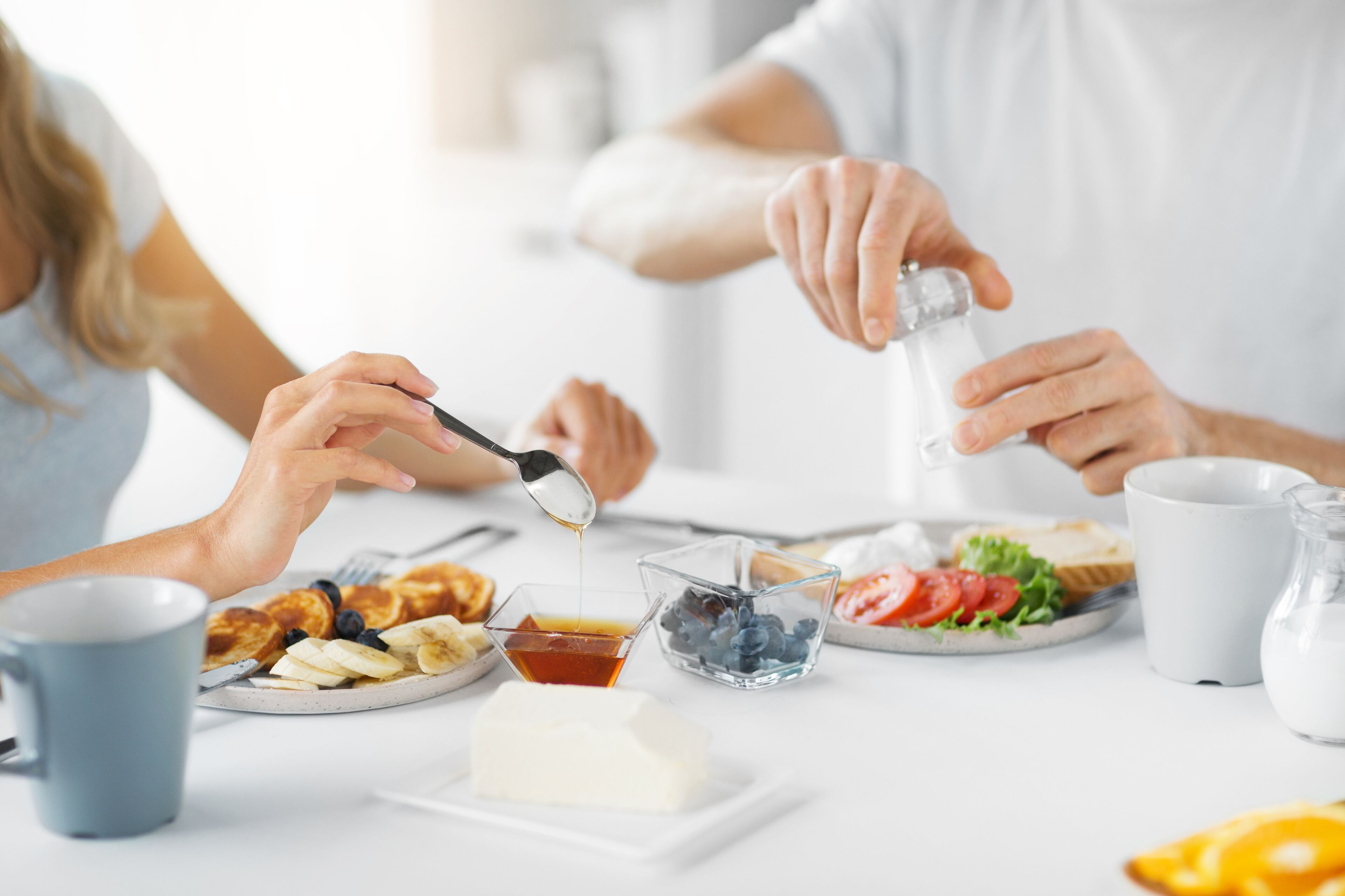 A breakfast setting with pancakes, blueberries, and a glass of milk on a table.