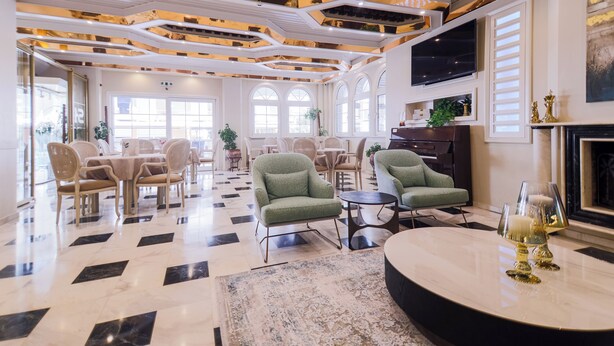 A spacious lobby with a checkered floor, multiple seating areas, and a fireplace. - Hotel Strass (Katerini)
