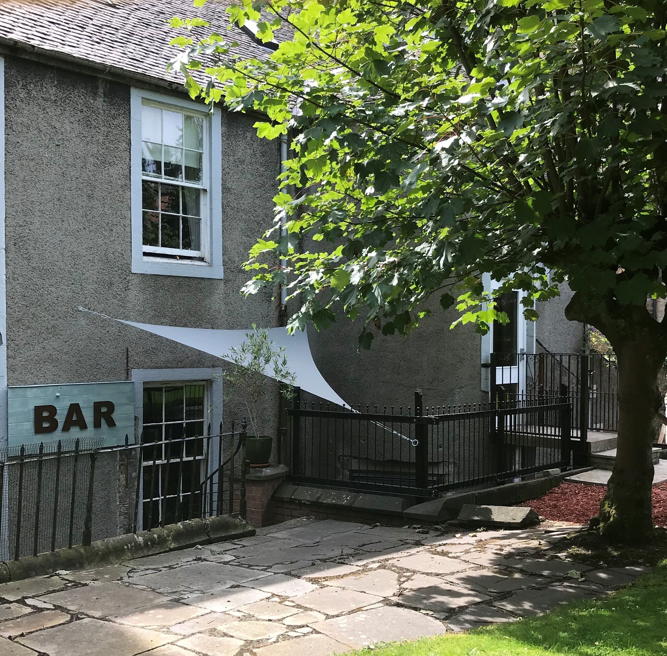 A building with a 'BAR' sign, a window, and a tree in front.