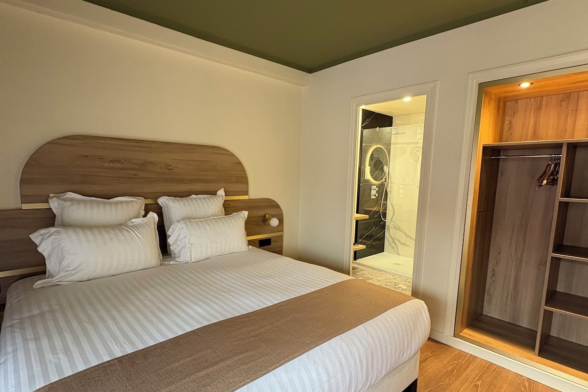 Un dormitorio con una cama grande, cabecera de madera y un vestidor con espejo.