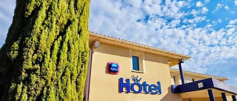 A hotel with a sign reading "Hotel Audotel" and a reception area with blue chairs and tables.