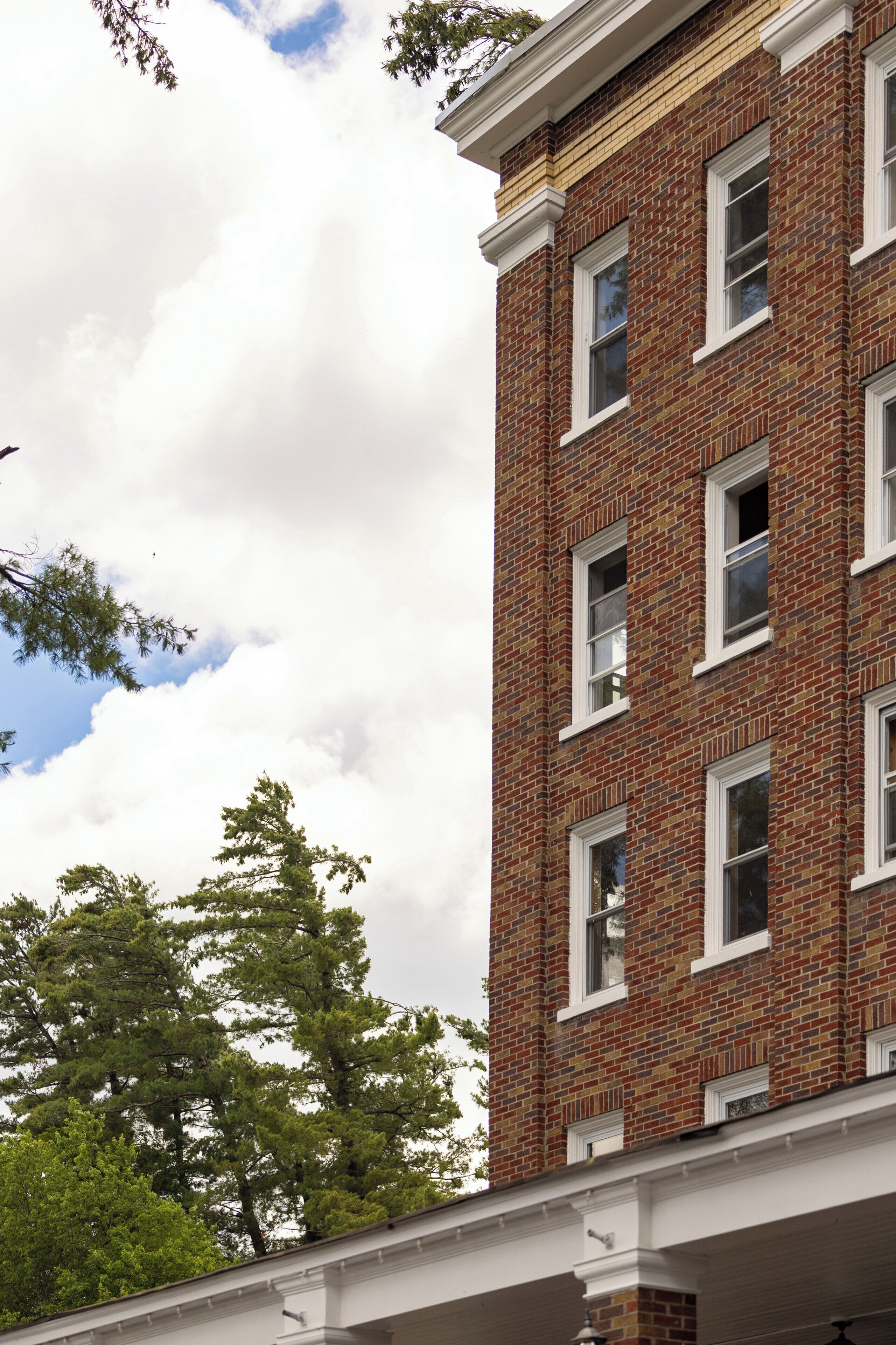 A multi-story brick building with white-framed windows and a flat roof.