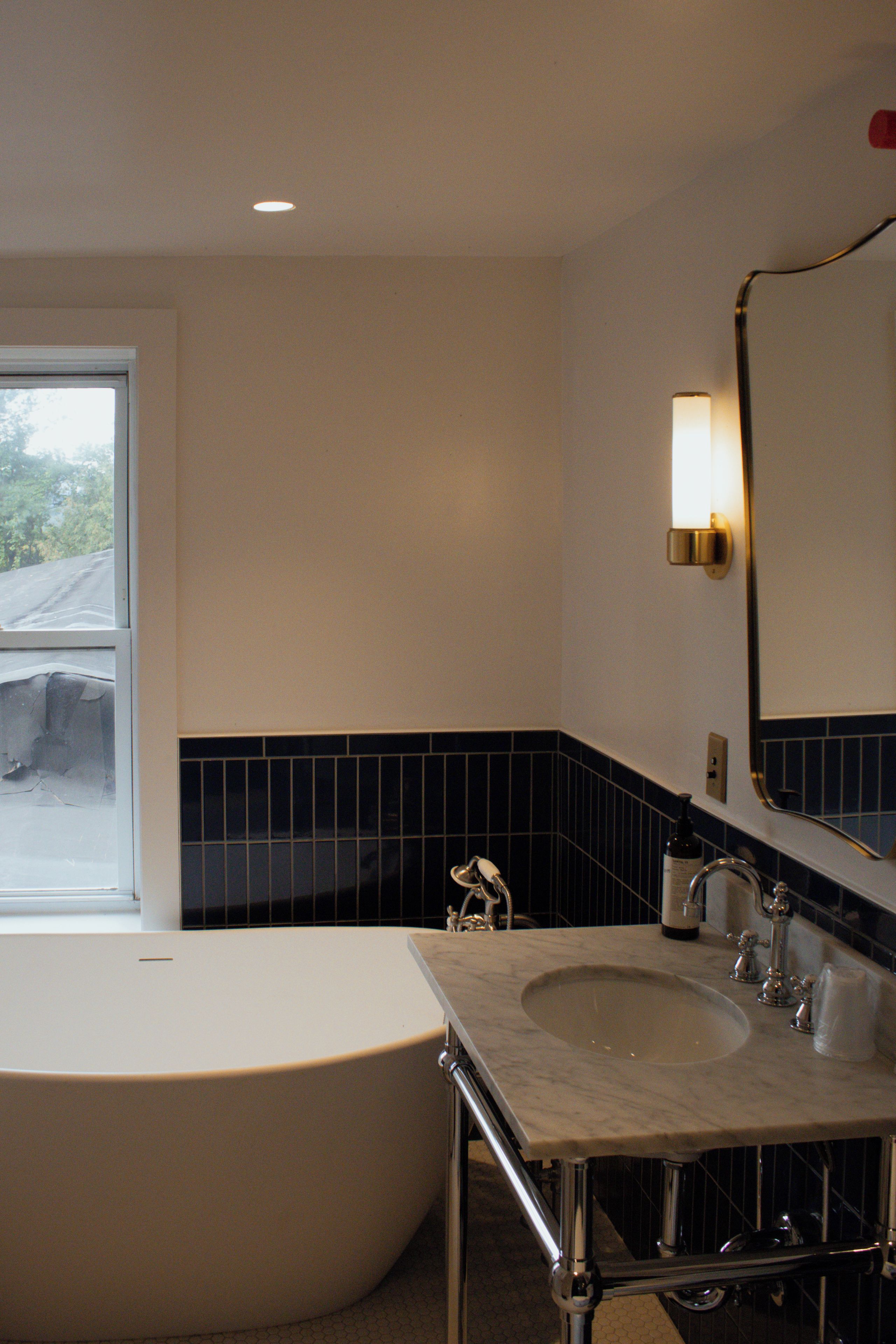 A bathroom with a bathtub, a sink, and a mirror.
