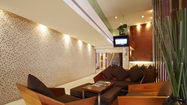 A modern interior with a seating area, a television, and a plant. - La Flora Resort Patong (Patong)