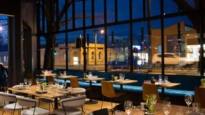 A restaurant with tables and chairs, large windows, and a view of the street outside. - The Sebel Launceston (Launceston)