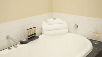 Un baño con bañera, un perchero y artículos de aseo.