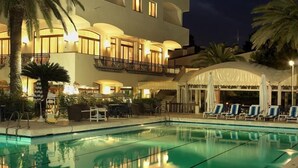 Un hôtel doté d’une piscine, d’un espace extérieur aménagé et d’une zone couverte.