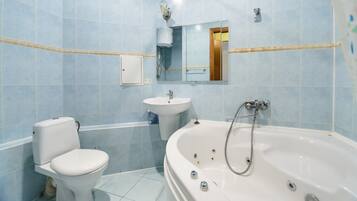 A bathroom with a toilet, sink, and bathtub.