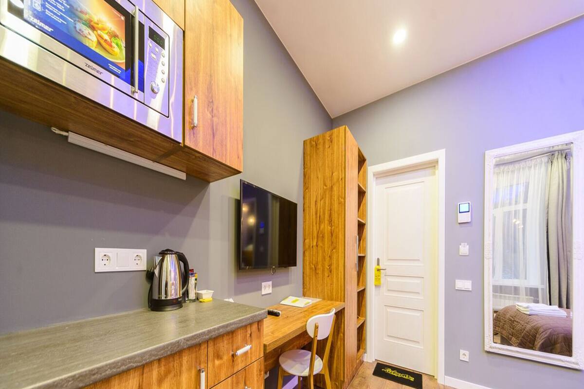 A compact kitchen with wooden cabinets, a built-in microwave, and a coffee maker.