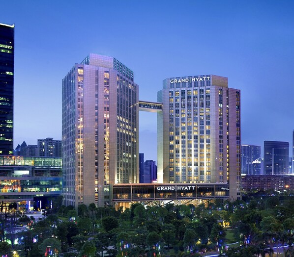 Un hotel Grand Hyatt con un diseño moderno, que presenta dos torres destacadas conectadas por un puente.