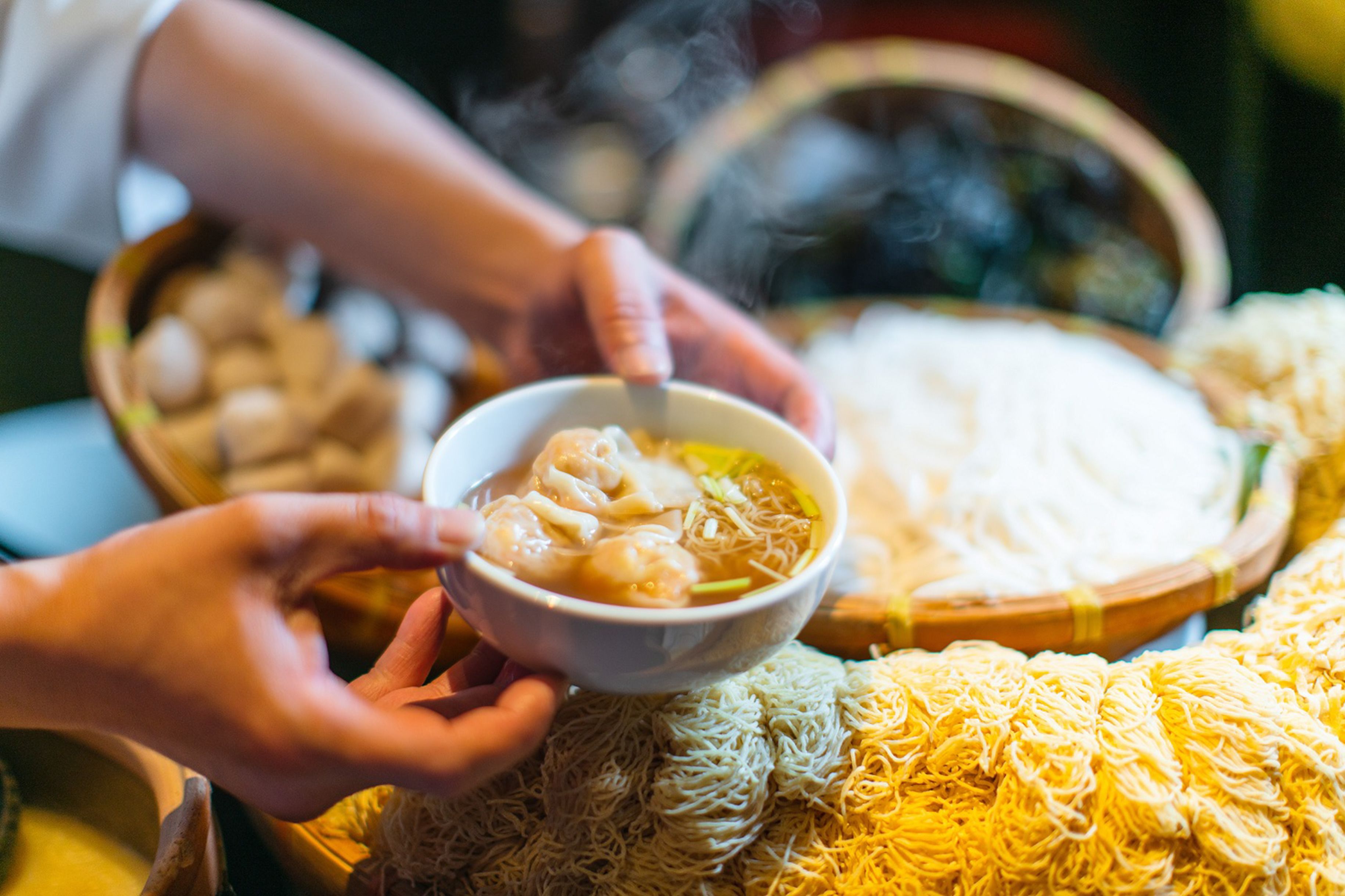 A bowl of noodle soup being served.