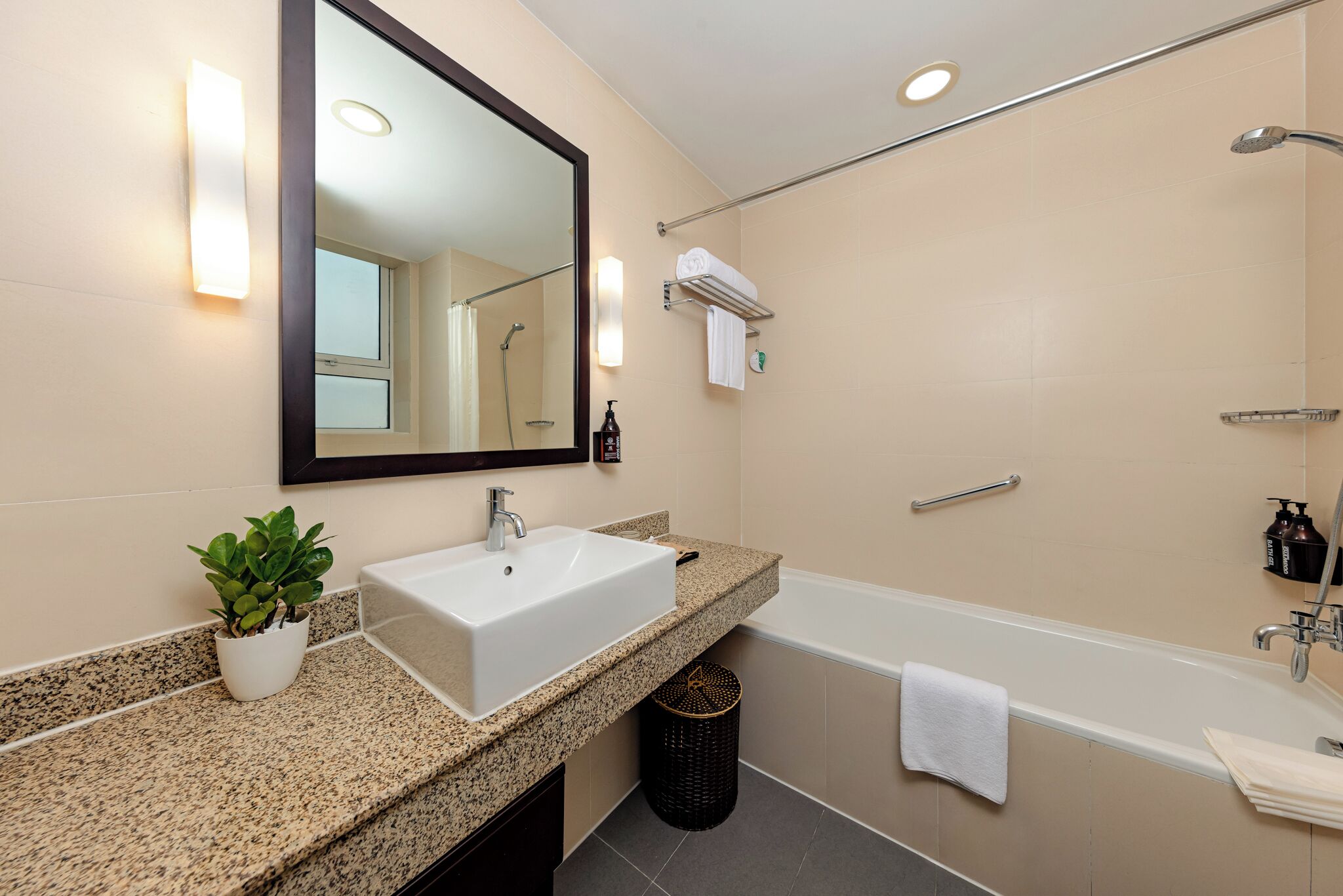 A modern bathroom with a sink, mirror, and bathtub.