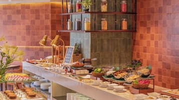 A buffet with various food items and a sign indicating breakfast options.