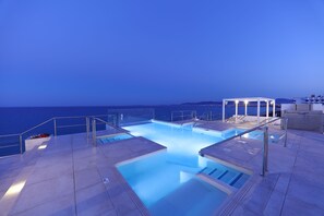 A swimming pool with a view of the sea at dusk. - Iberostar Waves Bahía de Palma -Adults Only (Palma de Mallorca)