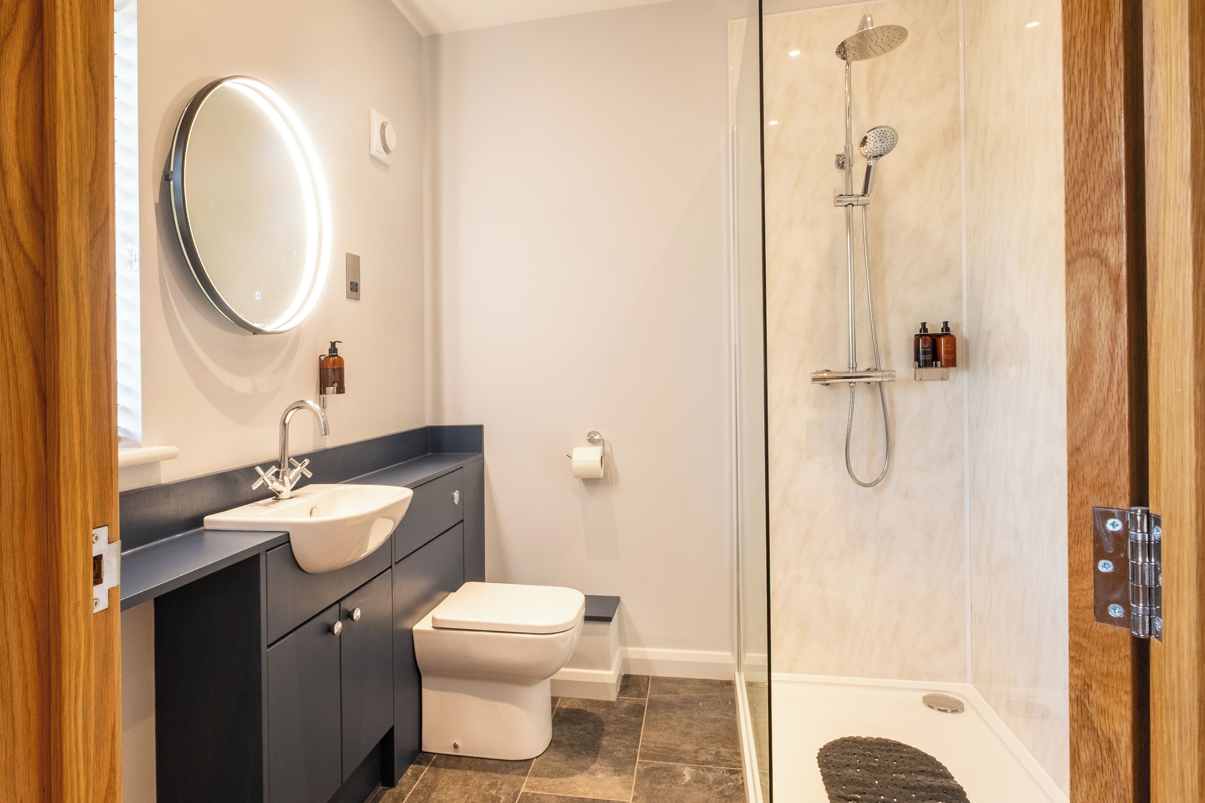A modern bathroom with a sink, toilet, and glass-enclosed shower.