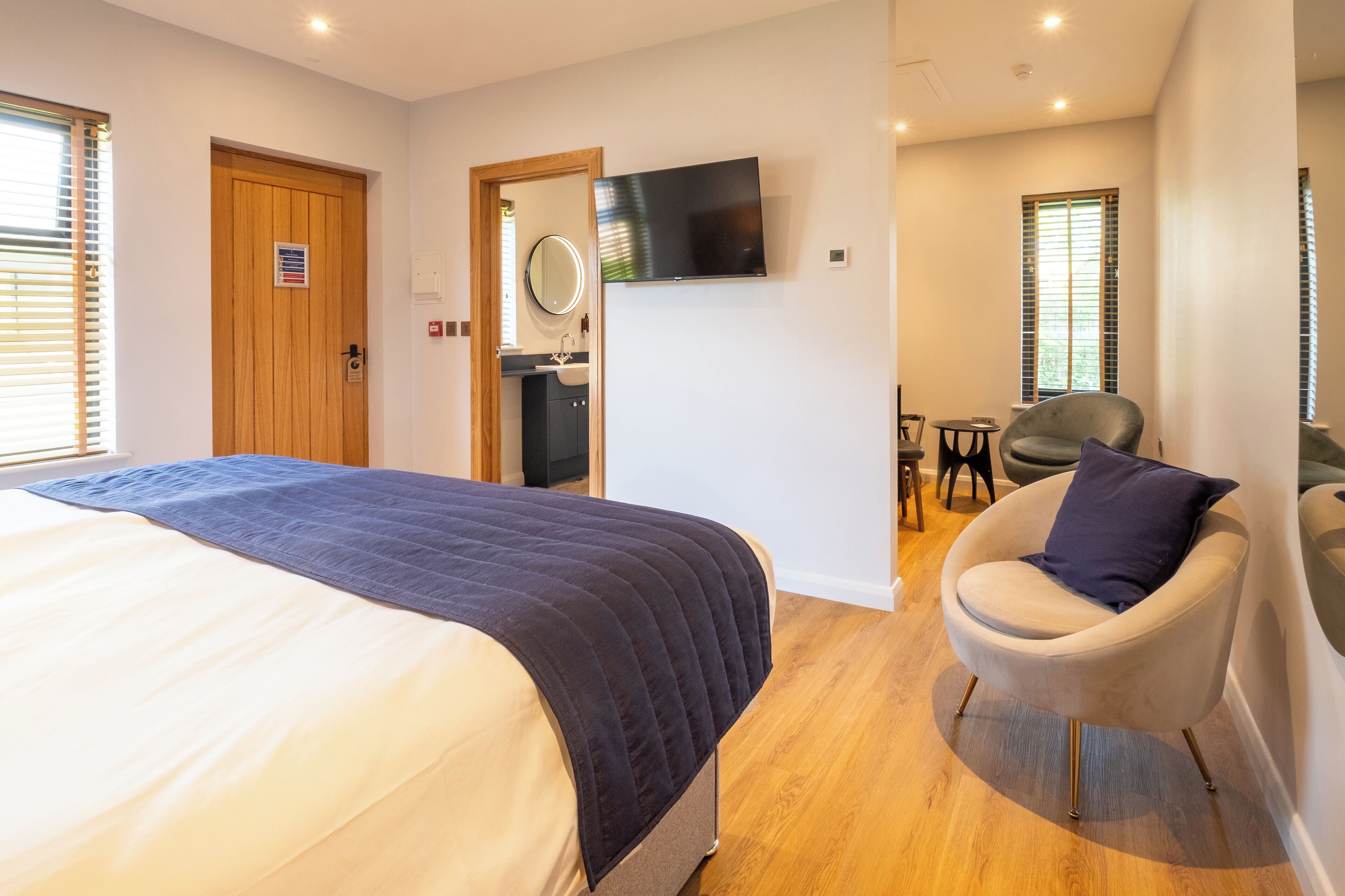 Une chambre d’hôtel avec un lit, une télévision, une chaise et une salle de bain.