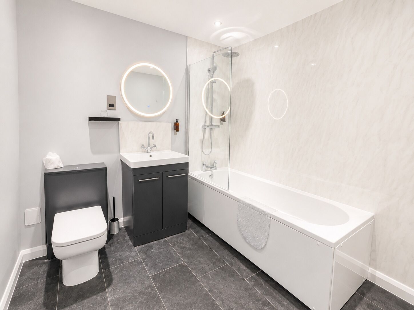 Un baño moderno con inodoro, lavabo y bañera.
