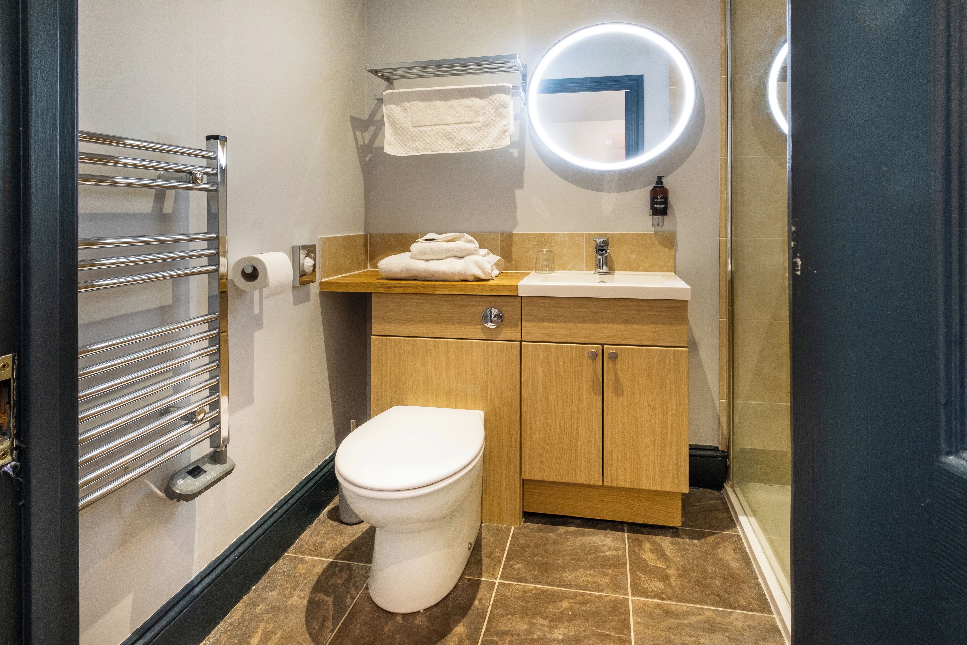 Un baño moderno con inodoro, lavamanos y toallero.
