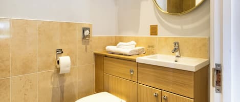 A modern bathroom with a toilet, sink, and vanity.
