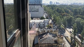 Blick aus einem Fenster auf einen Stadtblick mit einem Hilton Hotel, historischen Gebäuden und einem grünen Park.