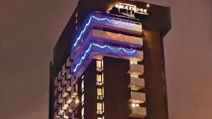 Ein hohes Hotel mit modernem Design, mit einer markanten Schilderung und beleuchteten Fenstern.