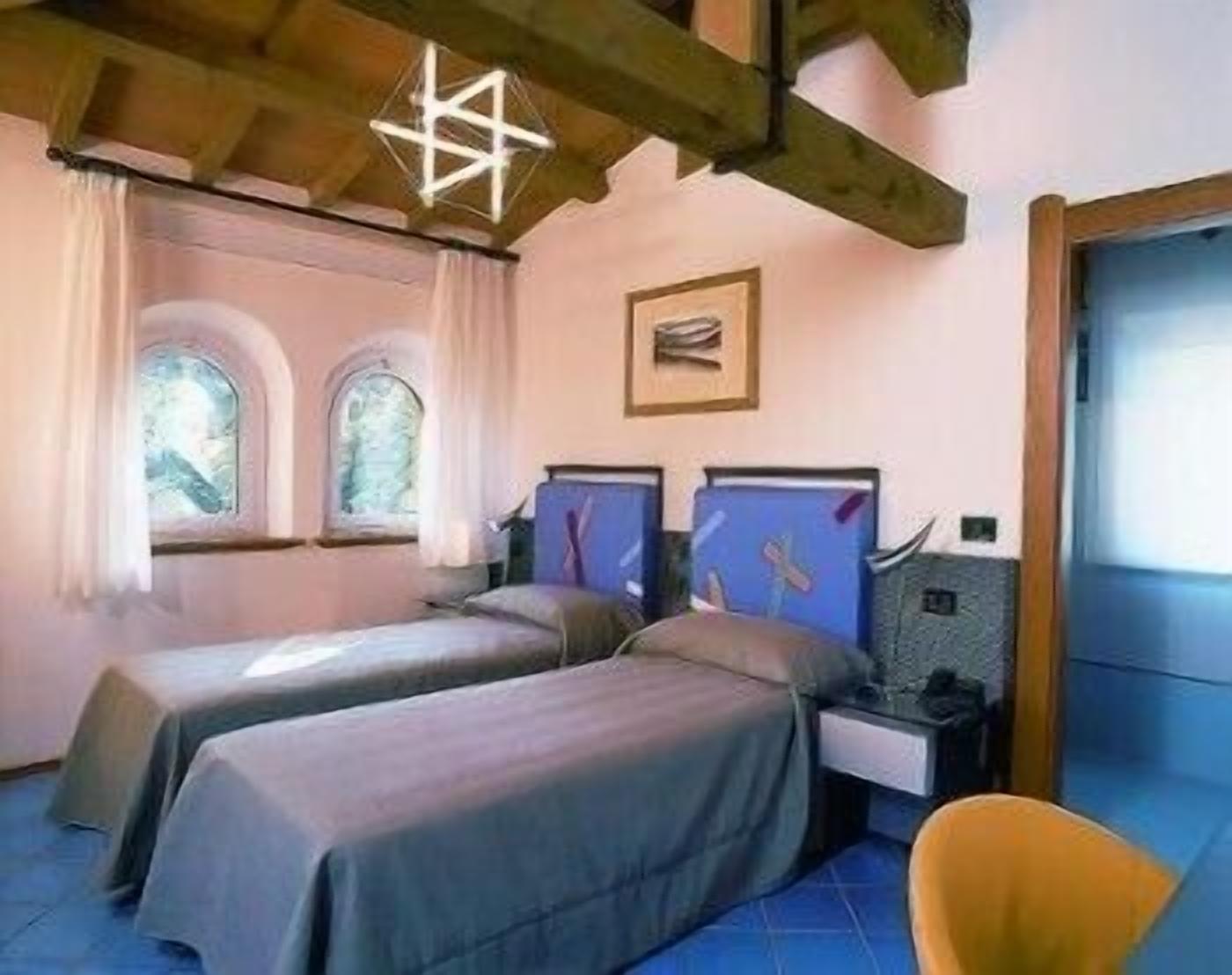 Una camera da letto con due letti singoli, un comodino, una sedia e una lampada a forma di stella.