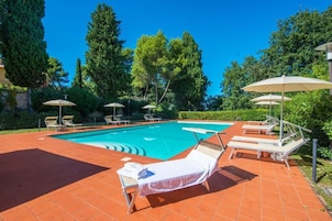 Una piscina al aire libre de temporada, sombrillas
