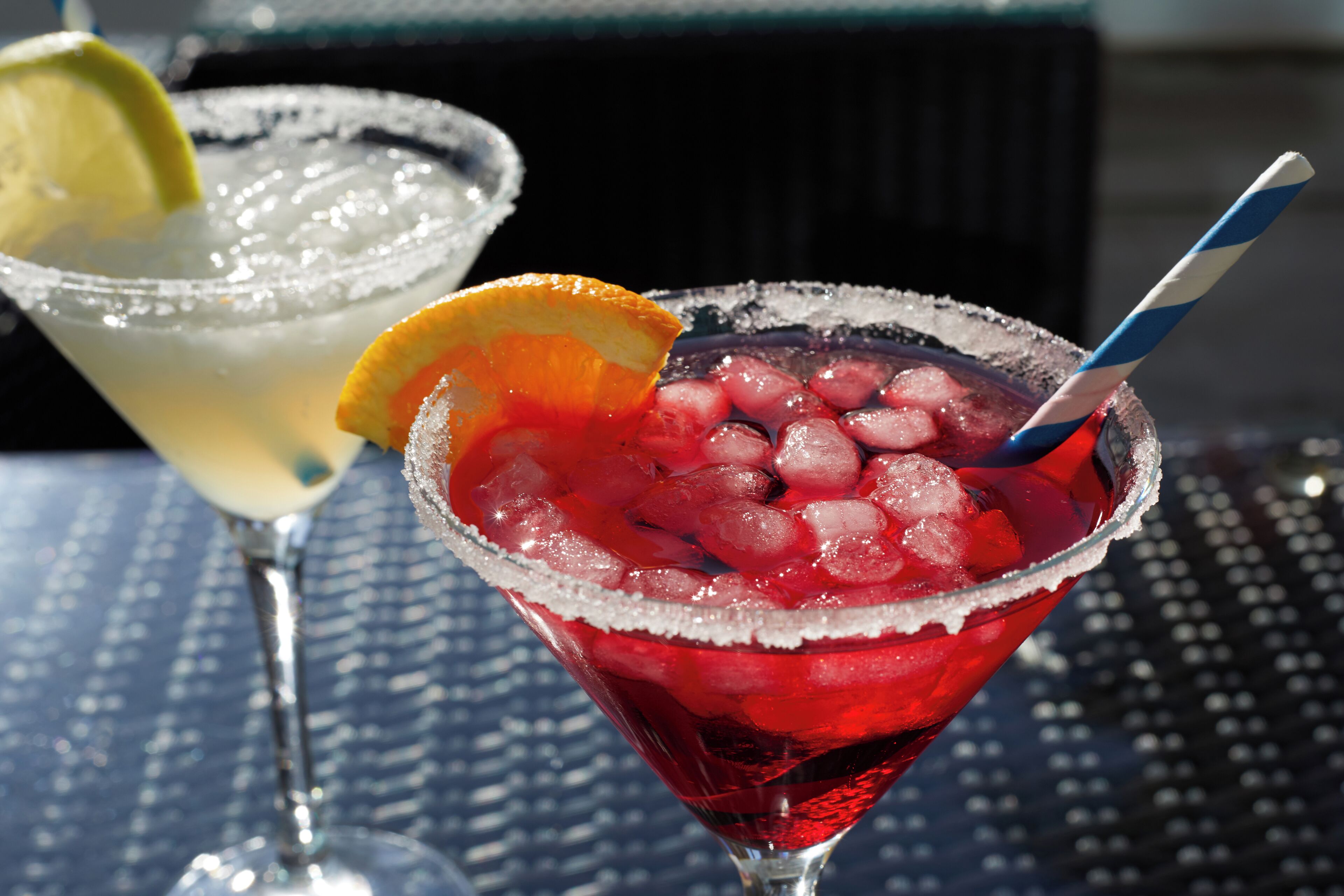 Two cocktails in martini glasses on a table.