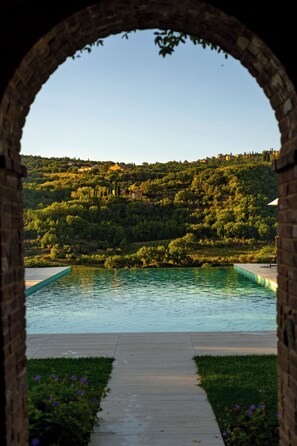 Una piscina al aire libre de temporada, sombrillas