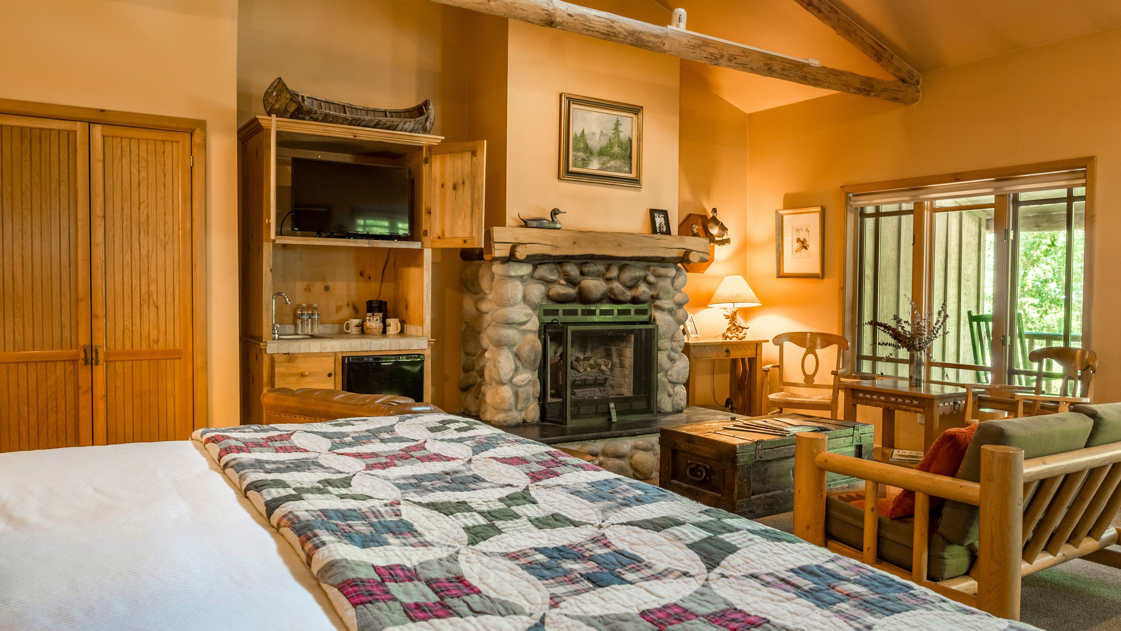 Una habitación acogedora con chimenea, muebles de madera y una cama con colcha.