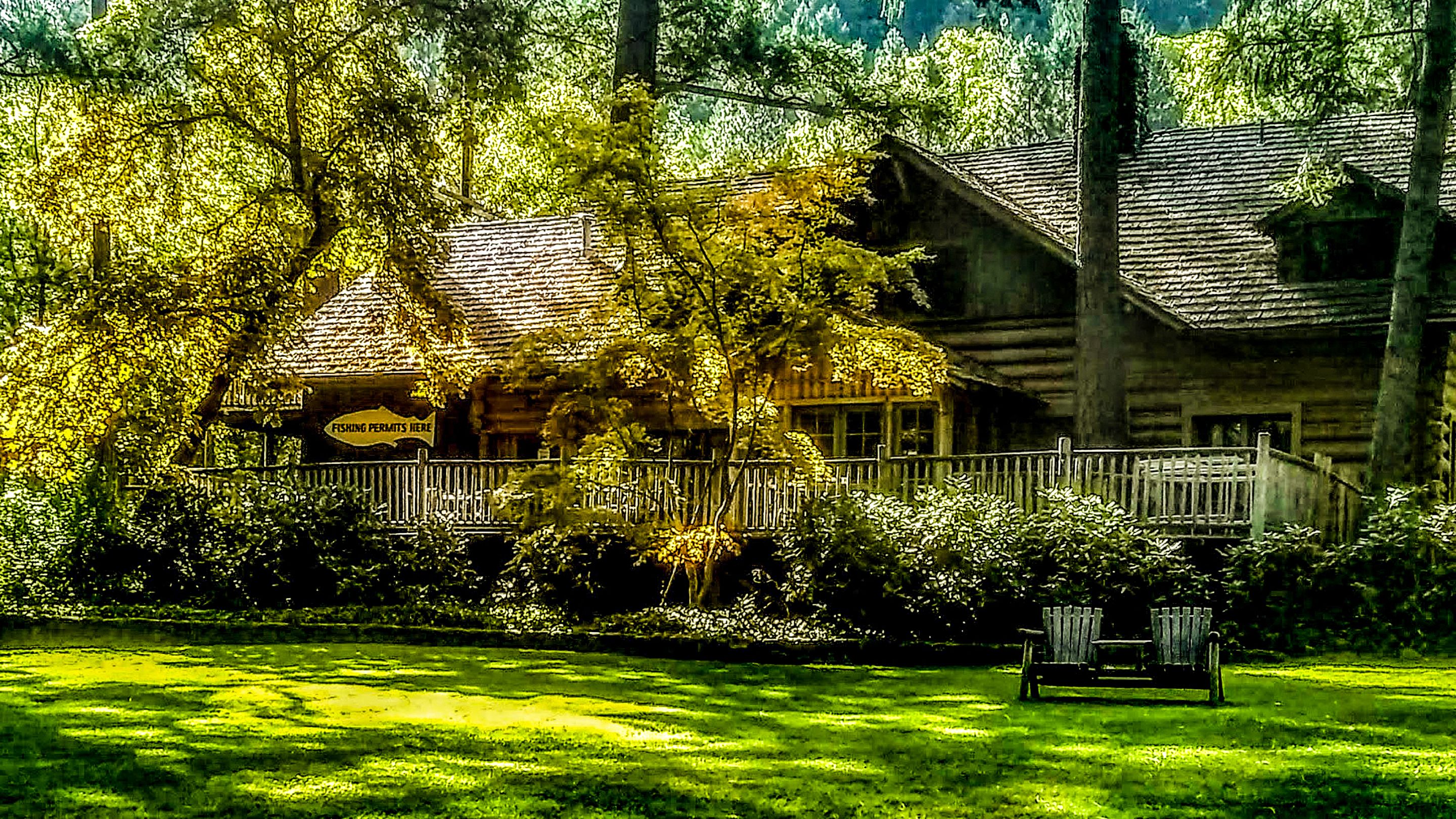 A rustic log cabin with a porch, surrounded by lush greenery and a sign indicating fishing permits.