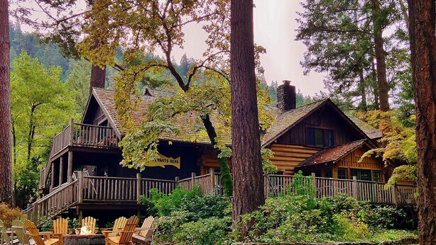 A cabin with a wooden deck and outdoor seating area. - Weasku Inn (Grants Pass)