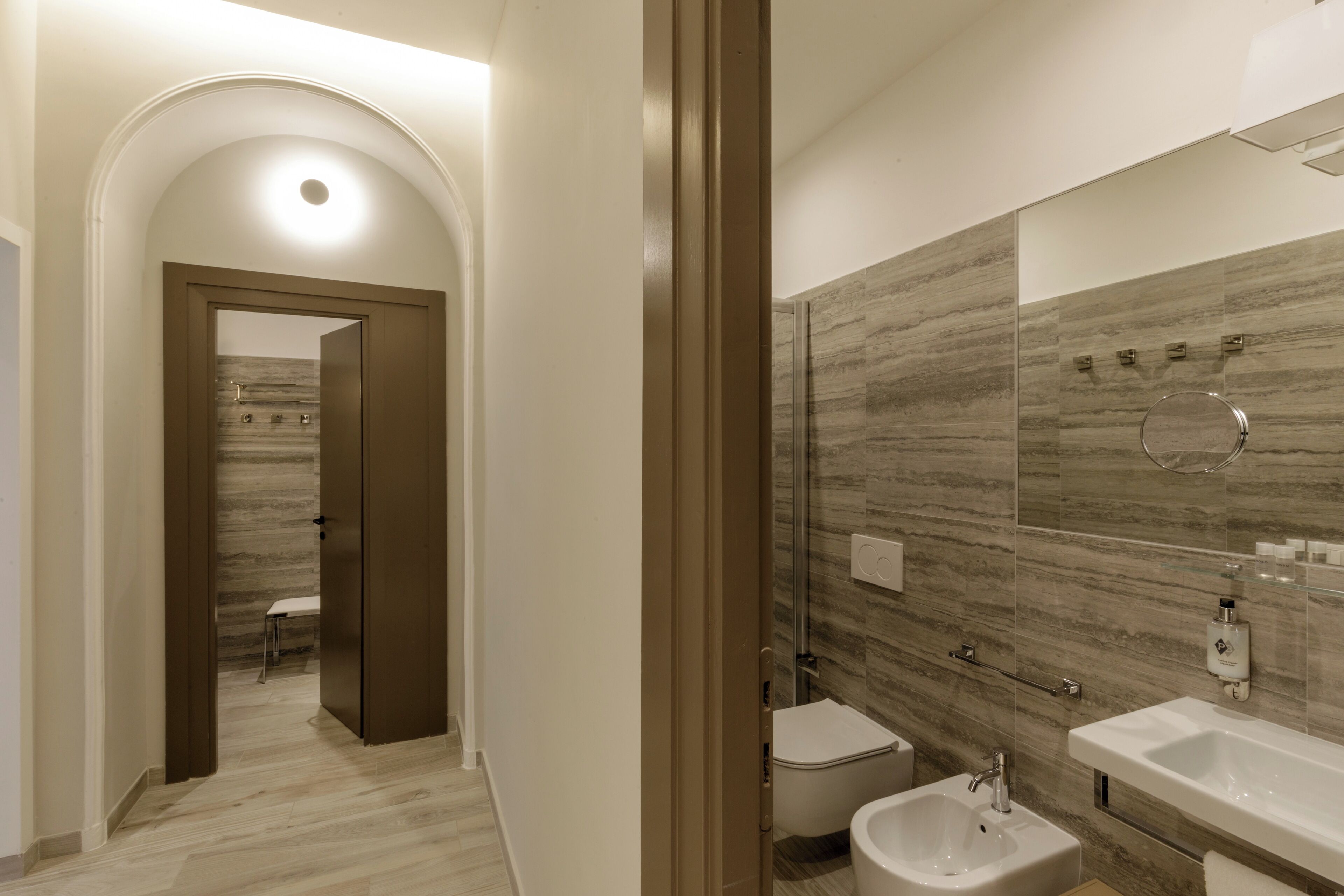 A modern bathroom with a large mirror, a bidet, and a sink.