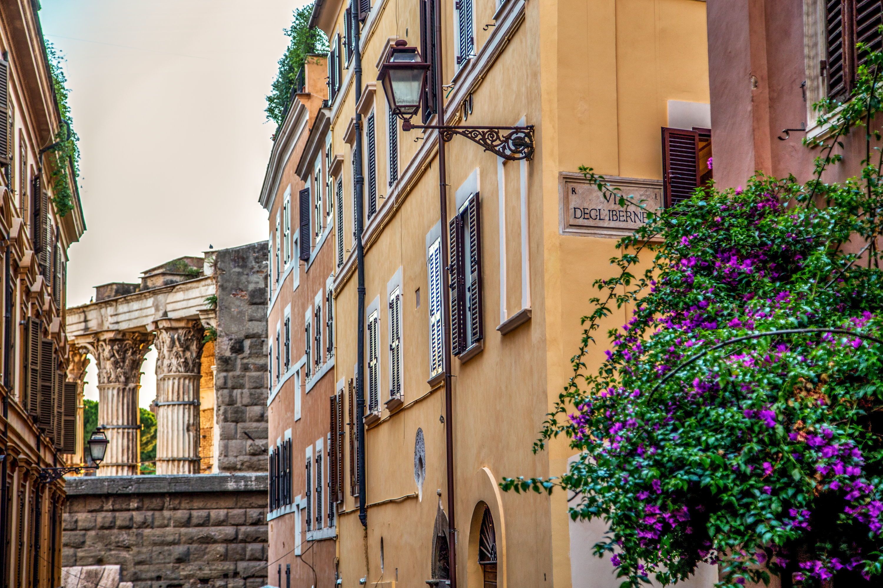 A narrow street with historic buildings, including a building with a sign reading "DEGL'IBERNE."