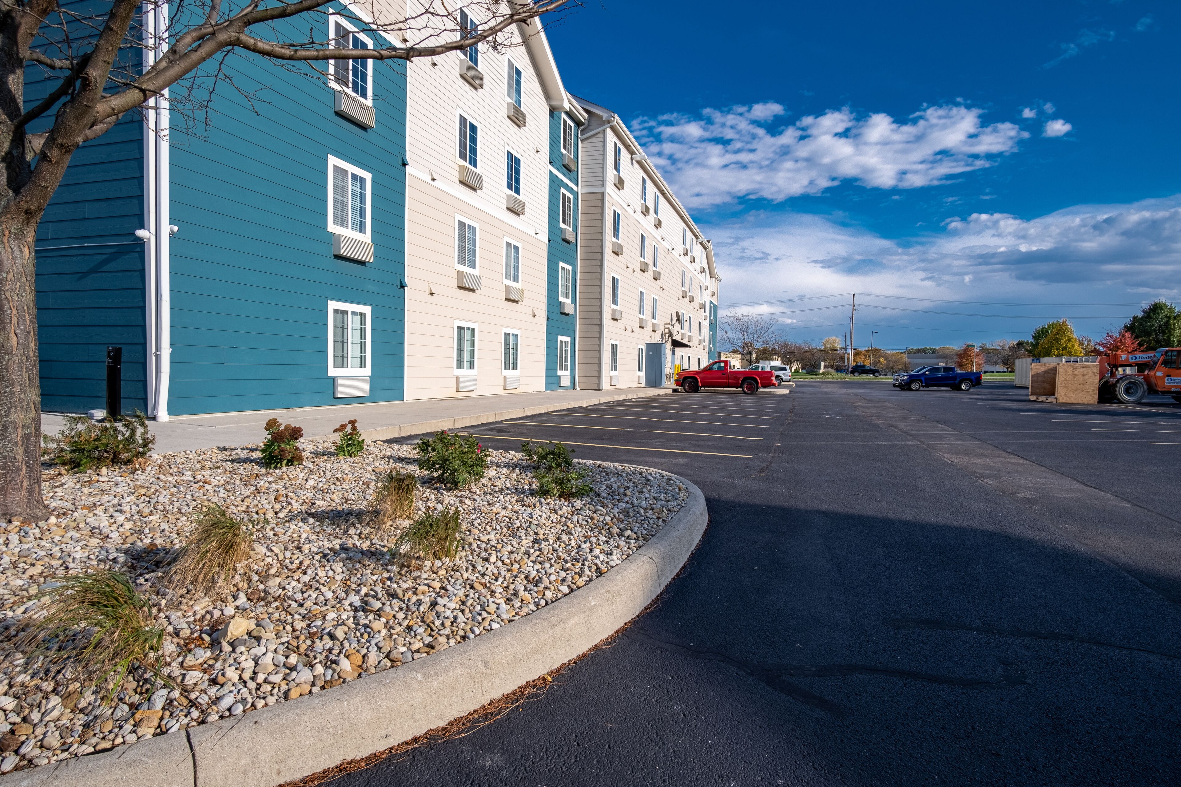 A multi-story residential building with a parking lot in front.