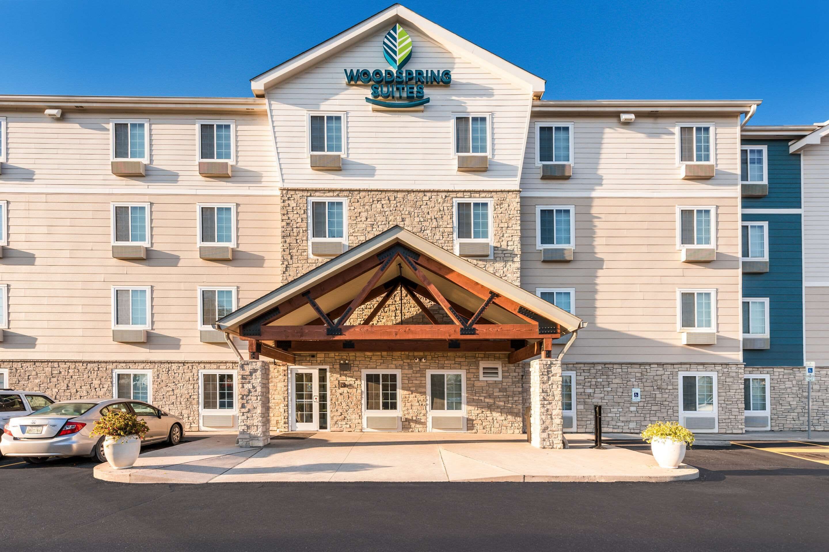 A multi-story hotel with a stone facade and a wooden entrance canopy.