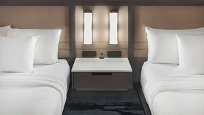 A hotel room with two beds, a central nightstand, and a wall-mounted light fixture. - Fairfield Inn & Suites by Marriott Cartersville (Cartersville)